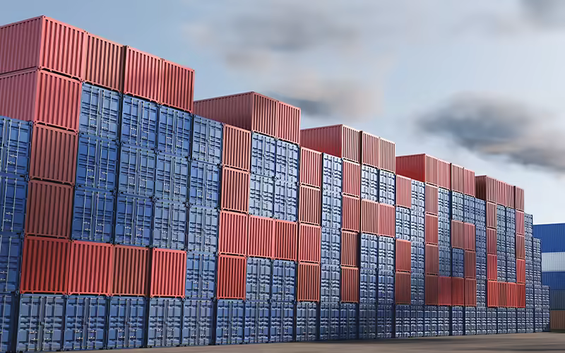 Shipping containers stacked at a terminal awaiting loading.
